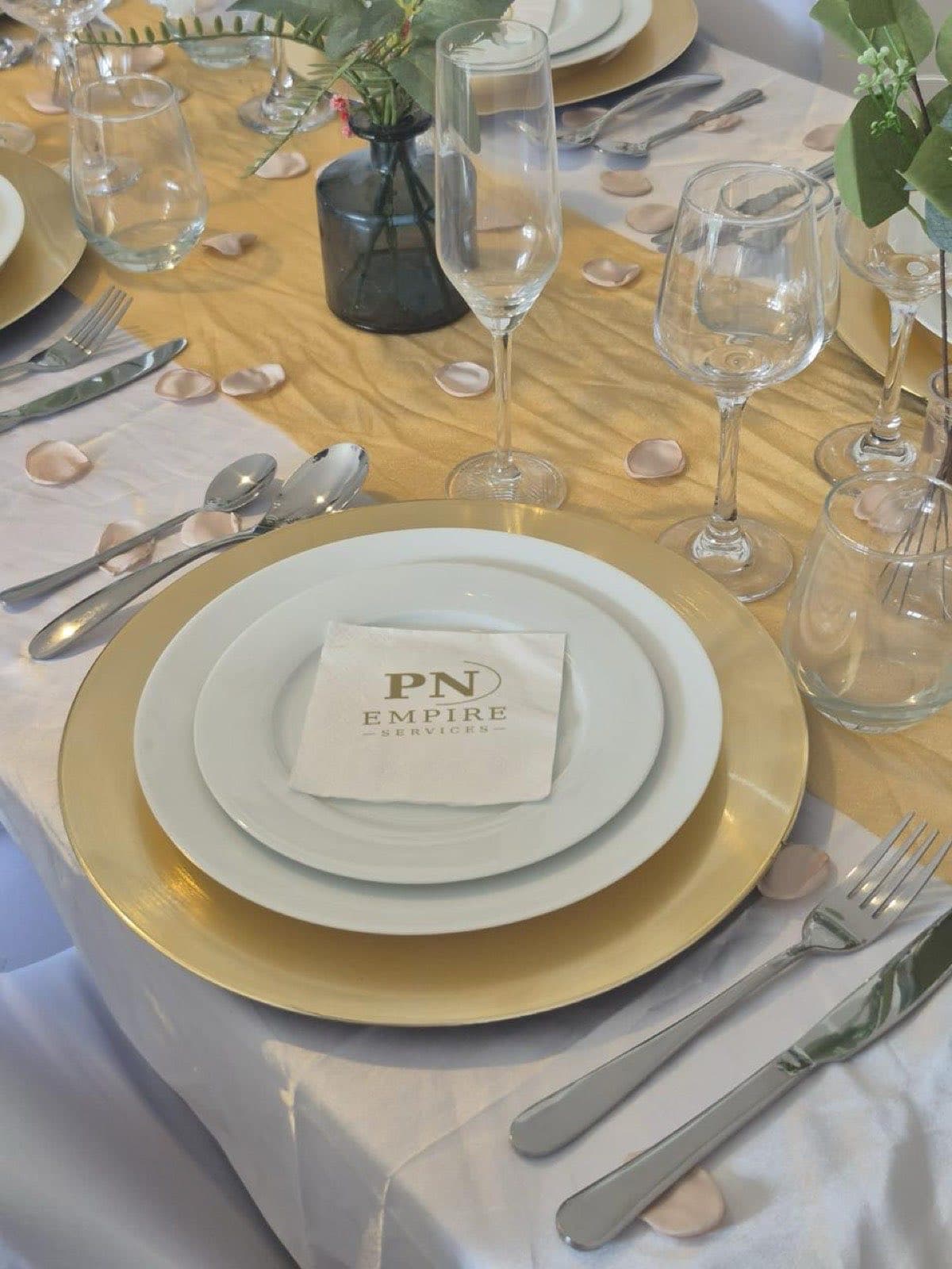 Table dressée avec assiettes dorées et serviette PN Empire Services